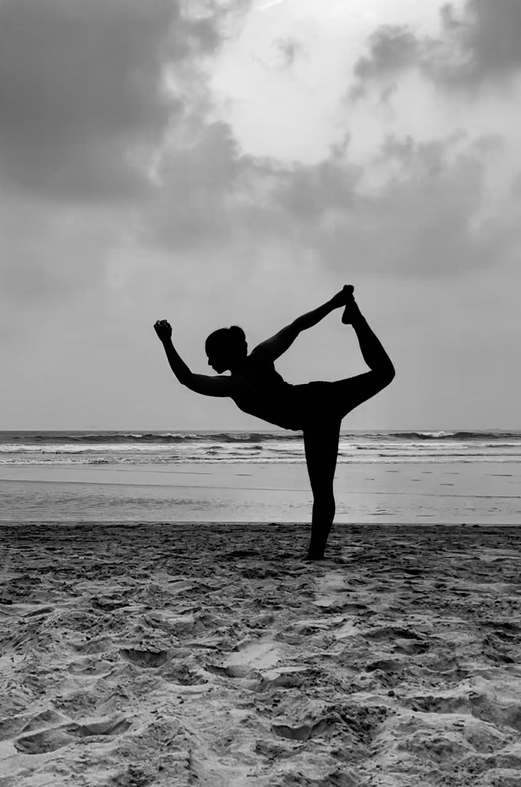 A woman in yoga natarajasana, silhouetted